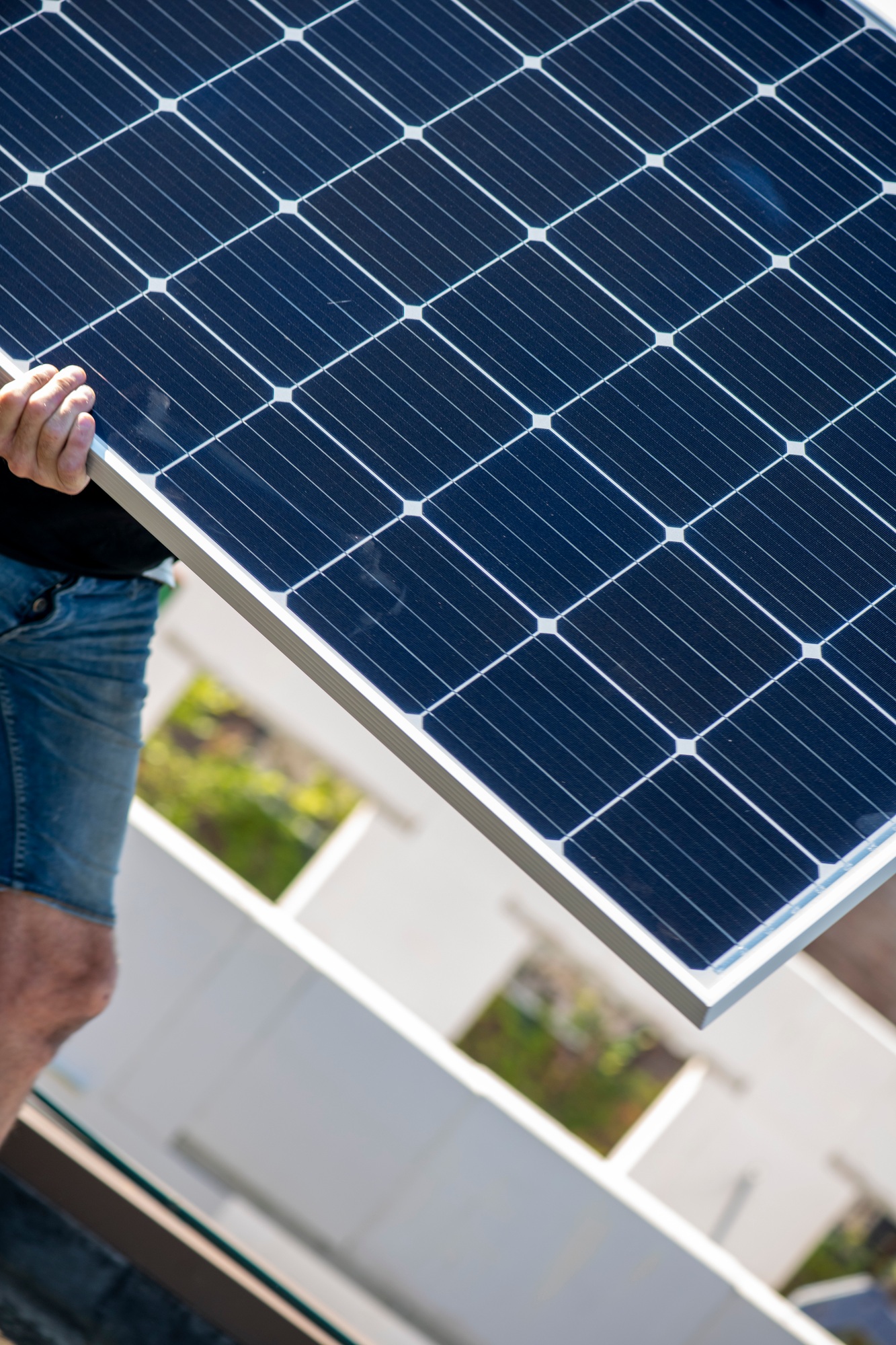 Man carrying solar panel with focus on clean energy